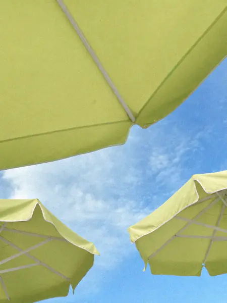 Hellgrüne Sonnenschirme vor blauem Himmel