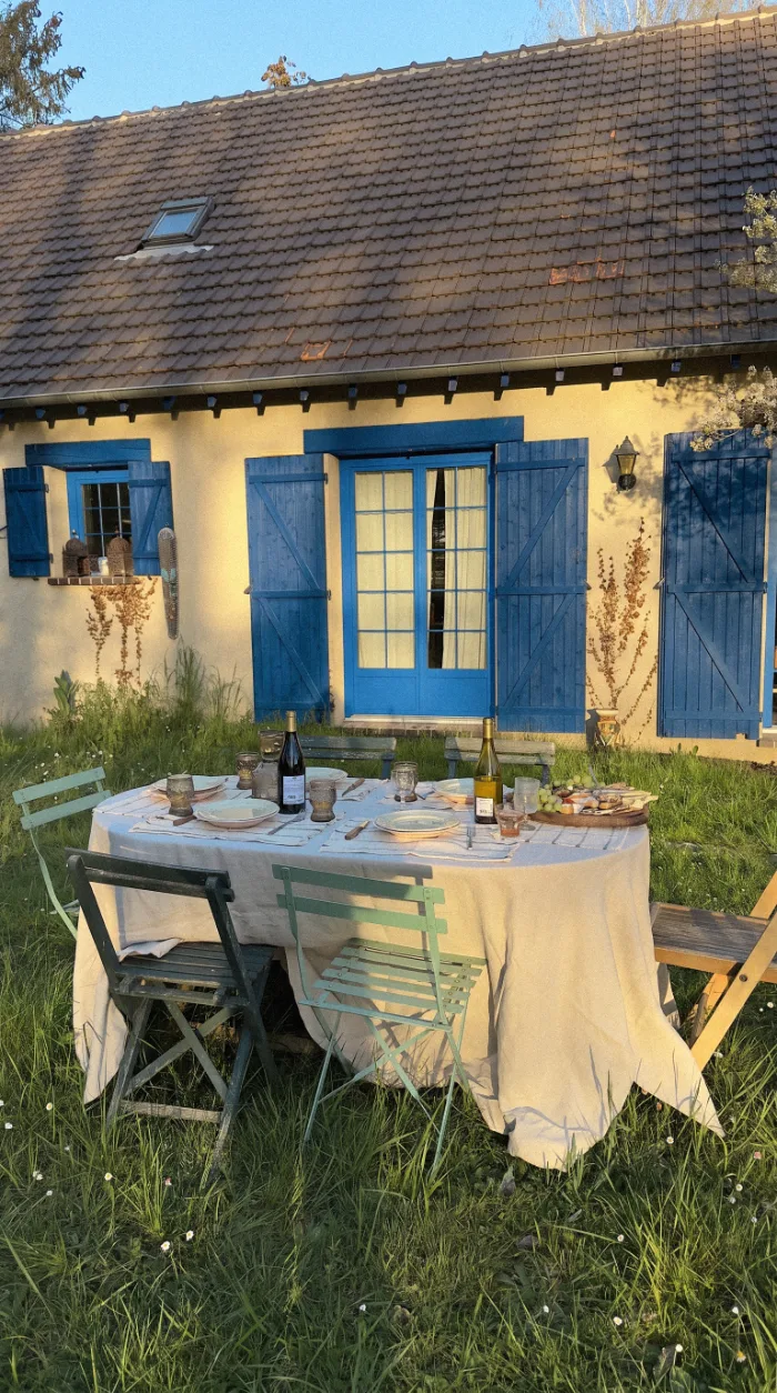 Τραπέζι κήπου έξω από εξοχική κατοικία με μπλε παντζούρια