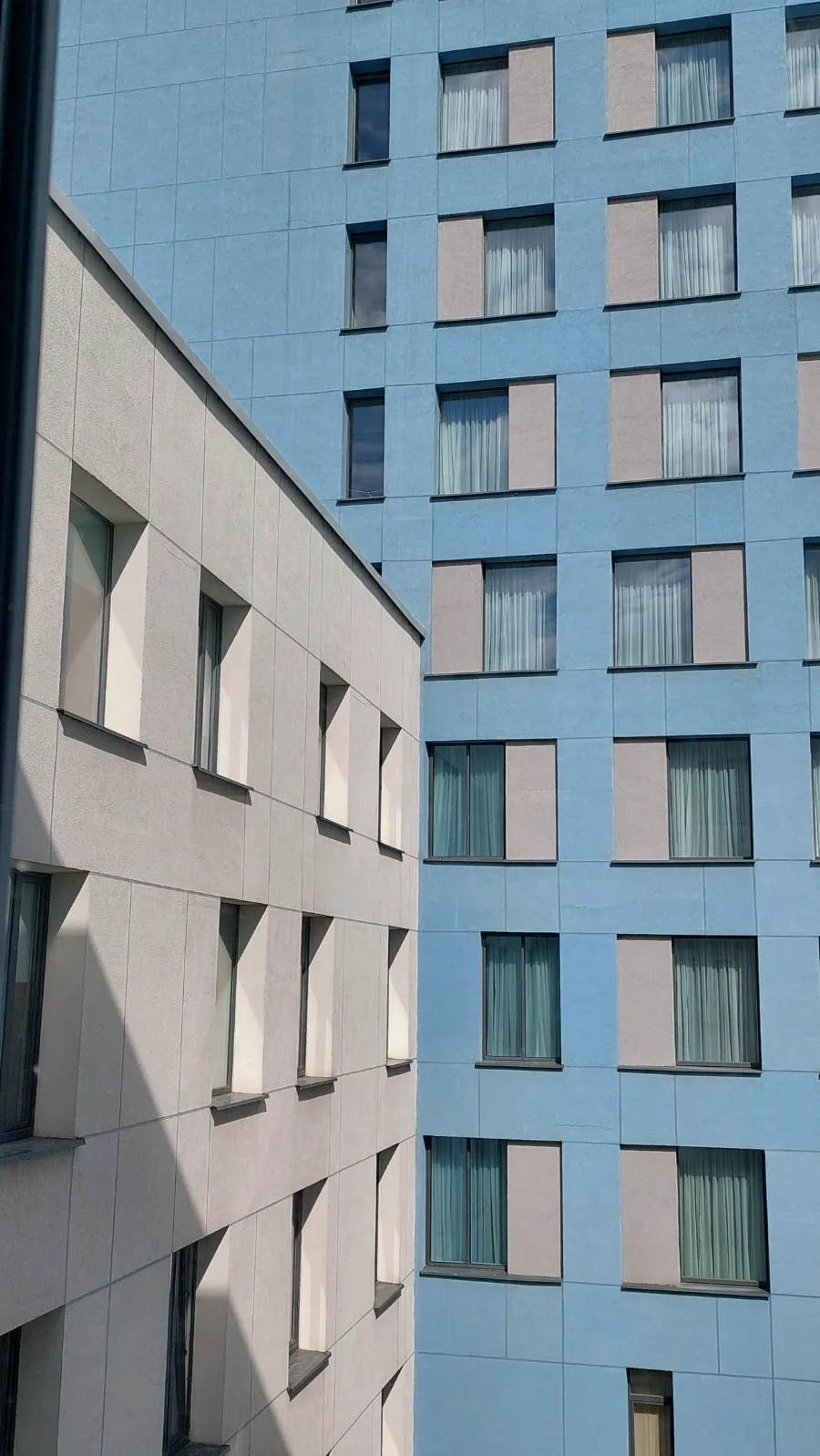 Modern szálloda homlokzata kék és szürke panelekkel