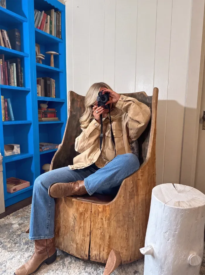 Gast mit Kamera in einer Hotelbibliothek mit blauen Regalen