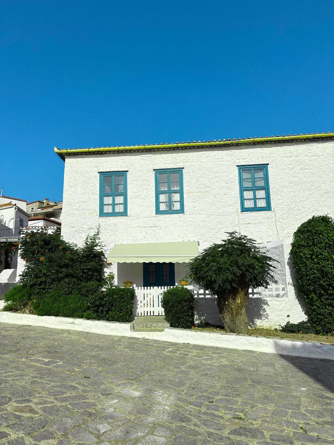 Fachada de hotel boutique encalada con contraventanas azules