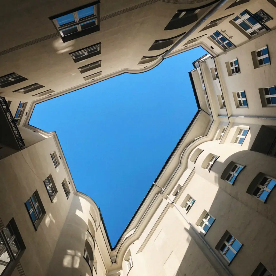 Blick aus dem Innenhof eines Budapester Wohnhauses nach oben in den Himmel