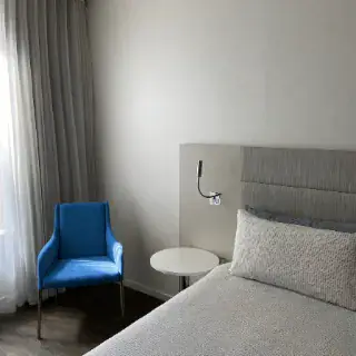 Schlafzimmer mit blauem Sessel am Fenster