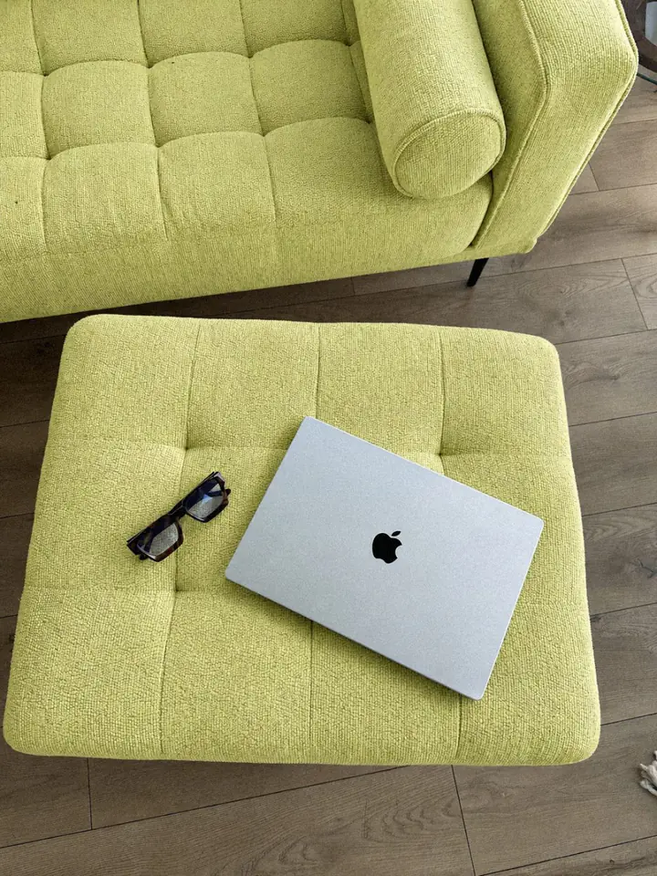 Laptop auf einem hellgrünen Sofa
