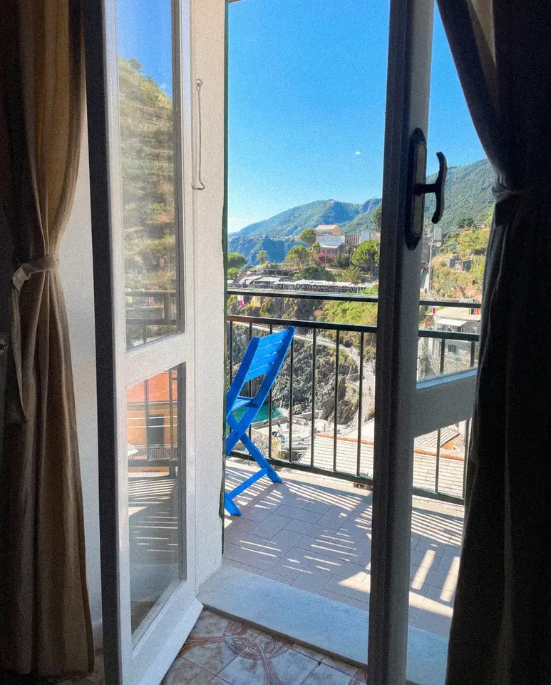 Mavi sandalye ve dağ manzarasına açılan balkon kapıları